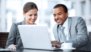 business woman and business man looking at laptop and smiling how it services make your business more competitive