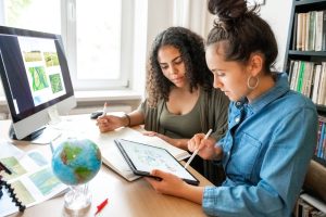 two young woman preparing together concepts for climate protection including eco friendly seo on desk indoors