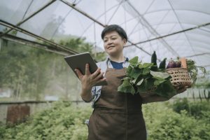 asian mid adult woman examining her organic farm growth with digital tablet eco friendly seo